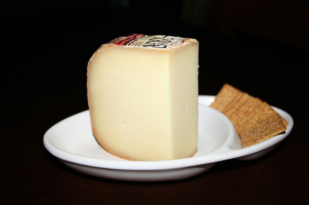 wedge of Ossau Iraty cheese on a white plate