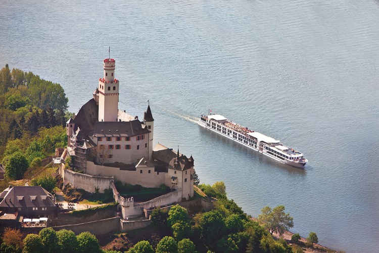 aerial view of cruise boat passing historic castle